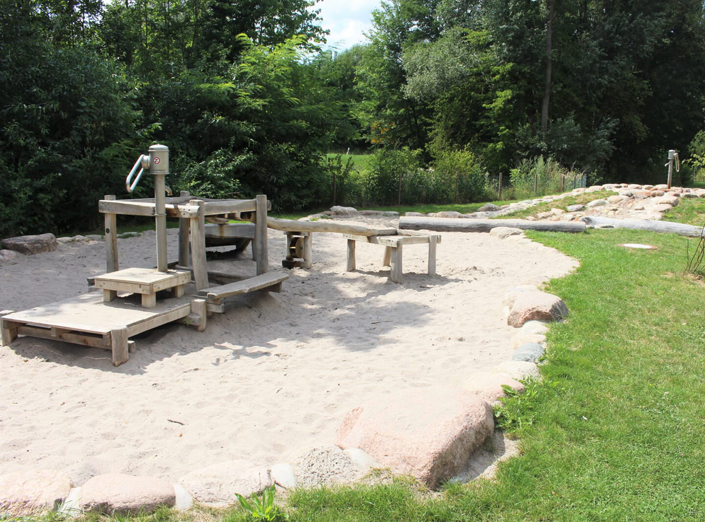 Spielanlage aus Holz auf großer Sandfläche